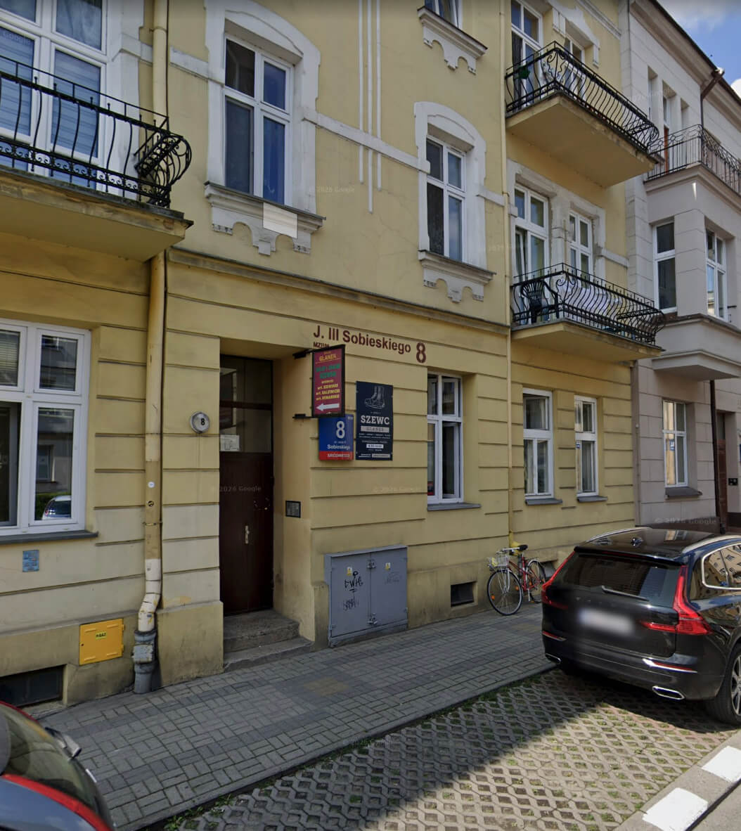 Kamienica przy ul. Jana III Sobieskiego 8 w Rzeszowie — brama wejściowa i szyld „Szewc Glanek” od strony ulicy